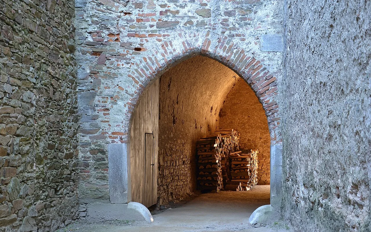The gate at Pernštejn Castle's fifth courtyard, thick Gothic stonework framing the passage